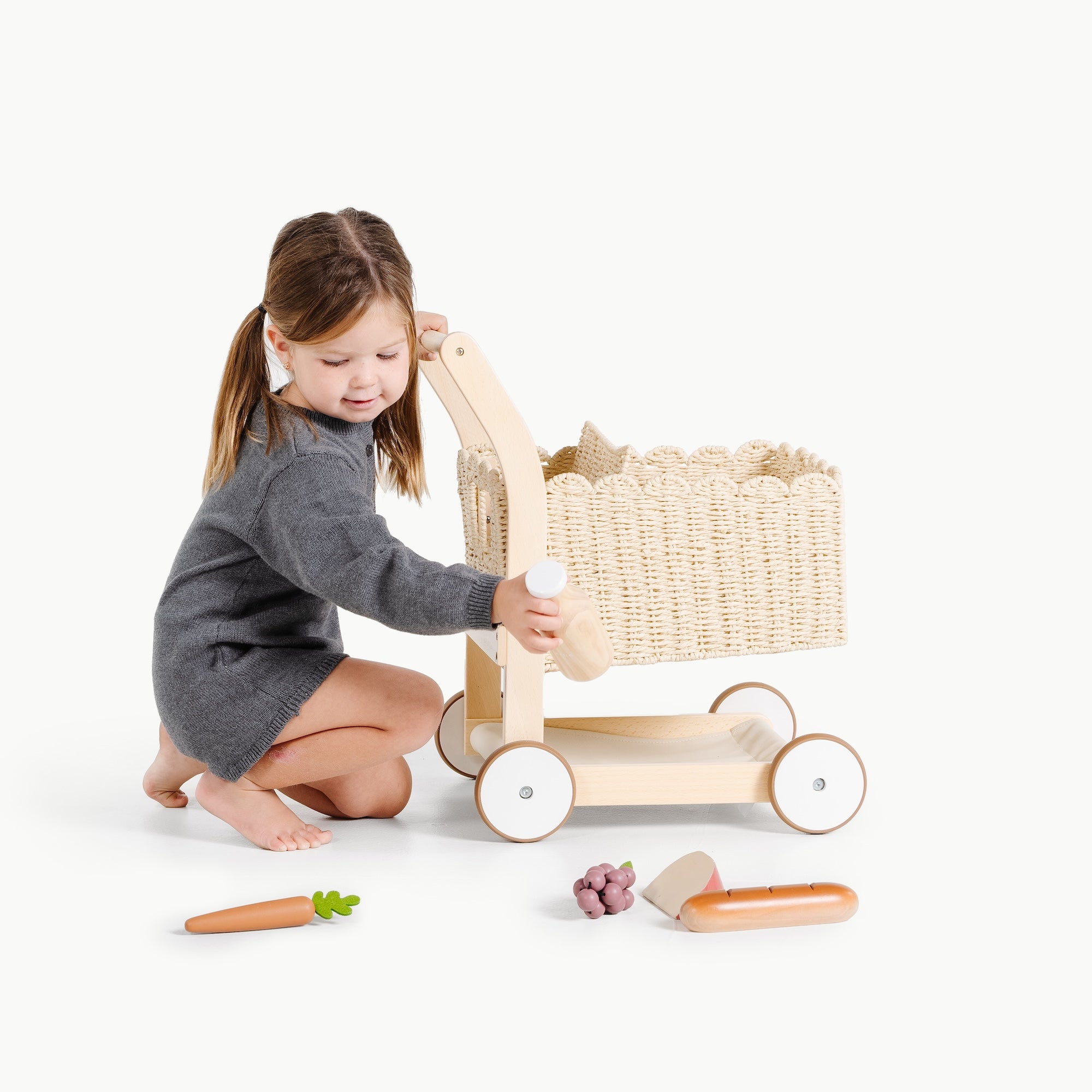 Ivory@Little girl playing with shopping trolley