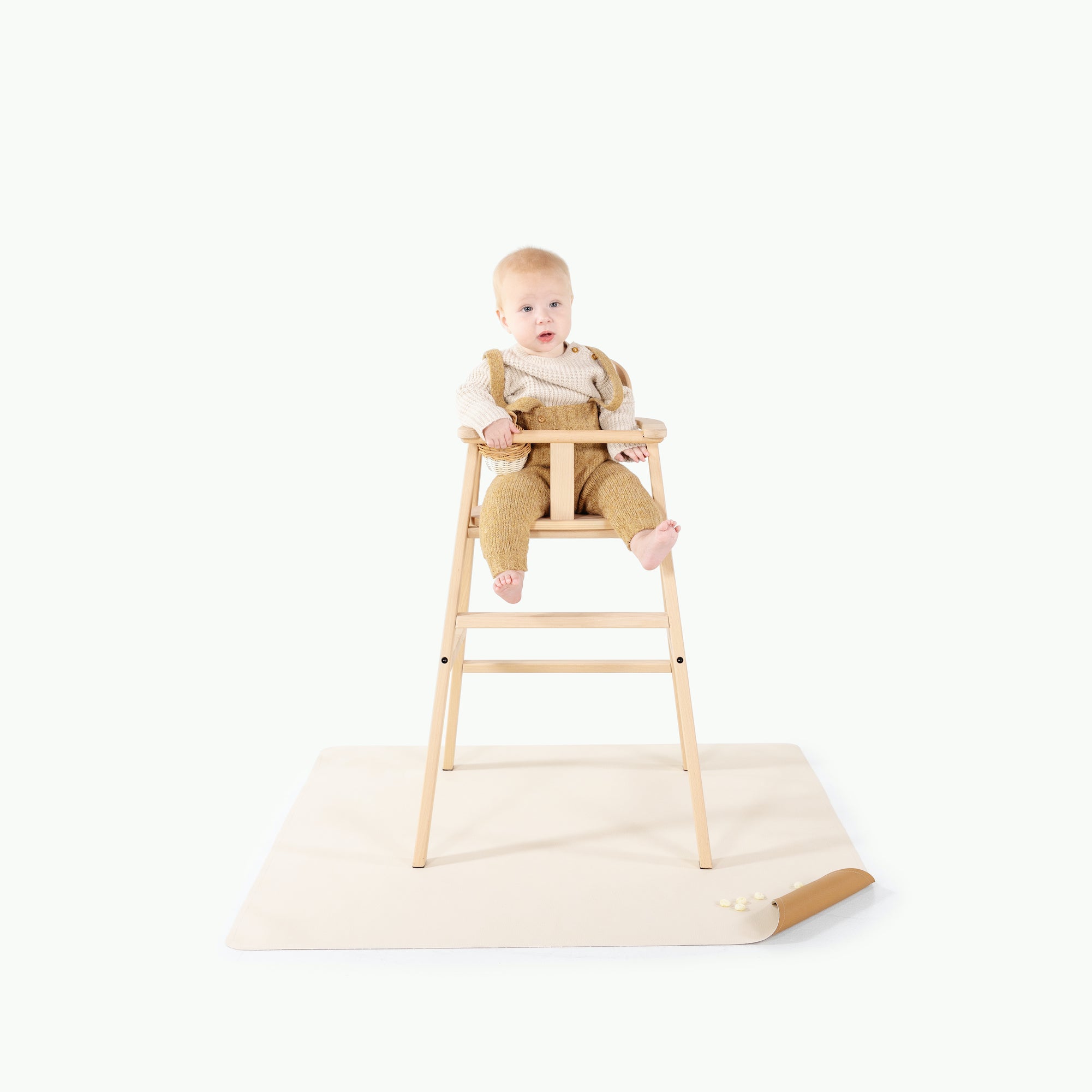Camel • Ivory@baby in a high chair on top of a mini mat