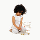 Biscotti / Square@Little girl playing with the square bead maze