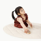 Ivory / Circle@Little girl playing on the Ivory Mini Circle Quilted Mat
