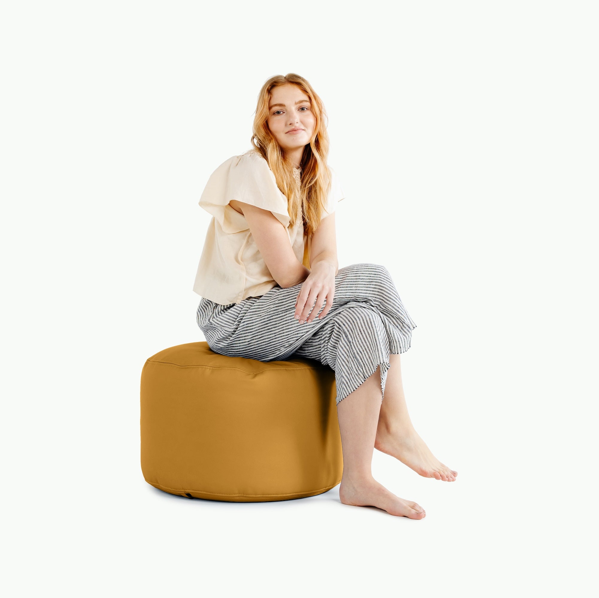 Saffron@woman sitting on a circle pouf