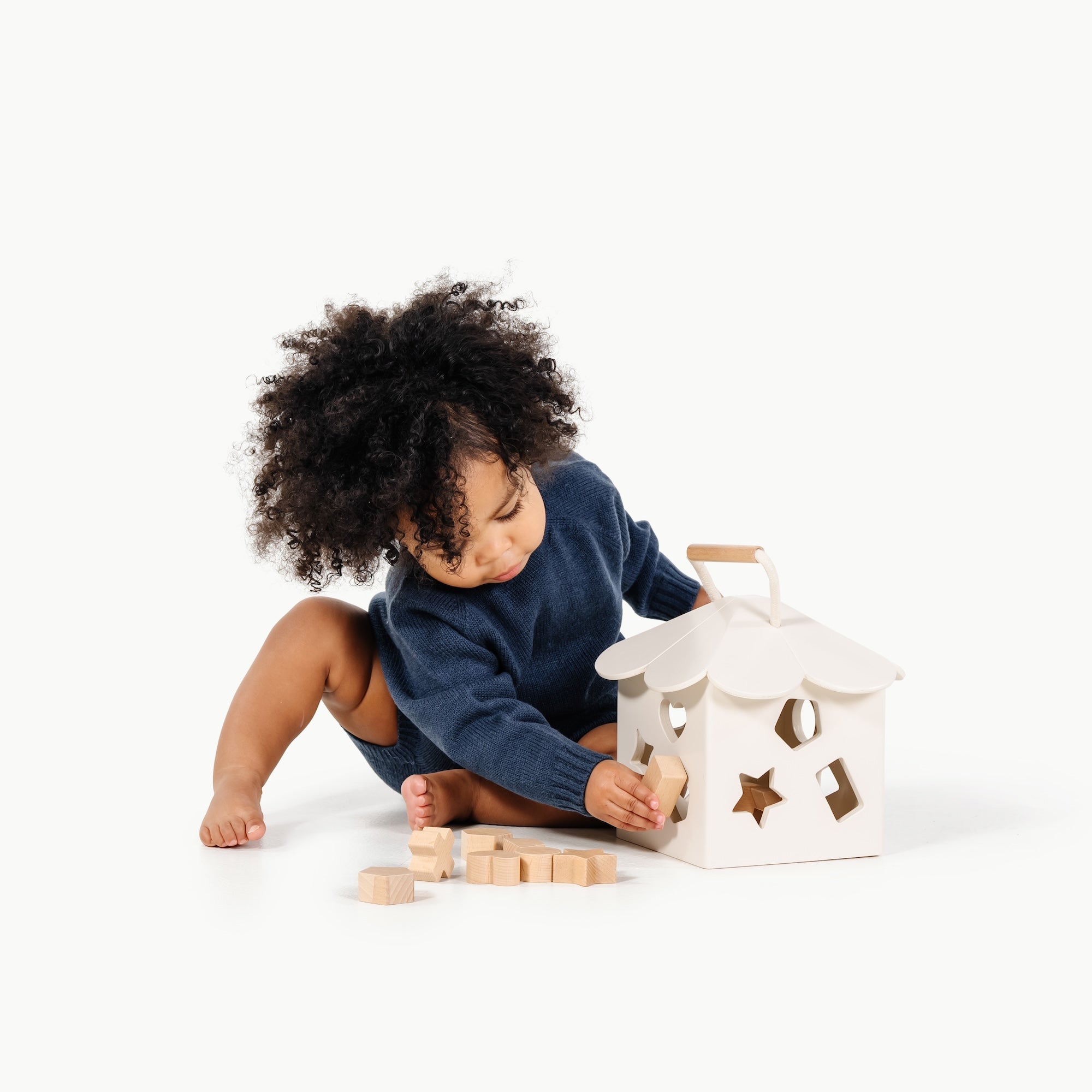 Ivory@child playing with the wooden shape sorter