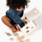 Ivory@child playing with the wooden shape sorter