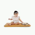 Tassel@little girl playing on padded mat