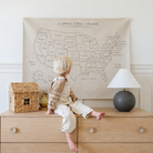 USA Map@kid sitting in front of the USA Map Mini+ Mat hanging on a wall