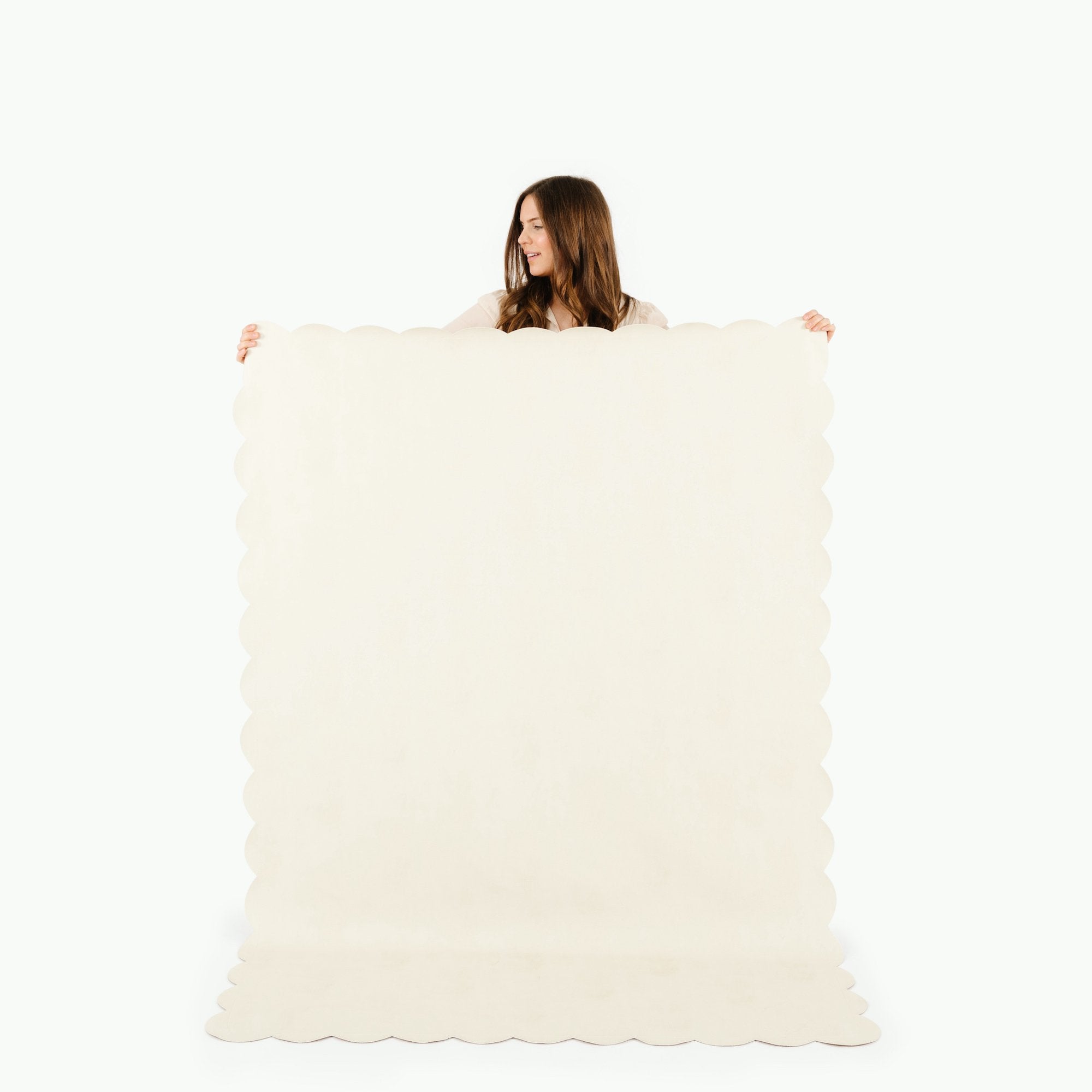 Ivory Scallop / 6 Foot@woman holding up ivory scallop tablecloth
