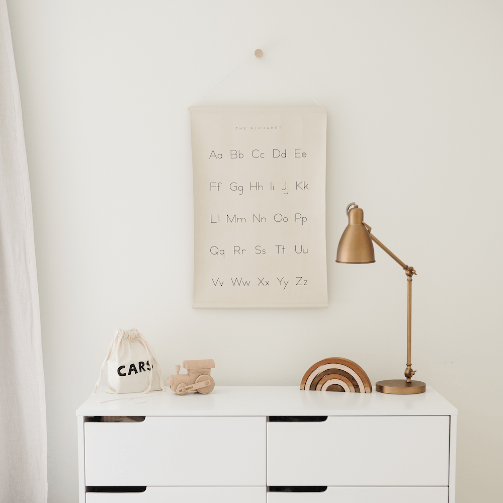 Alphabet@Alphabet Poster hanging above a dresser in a bedroom