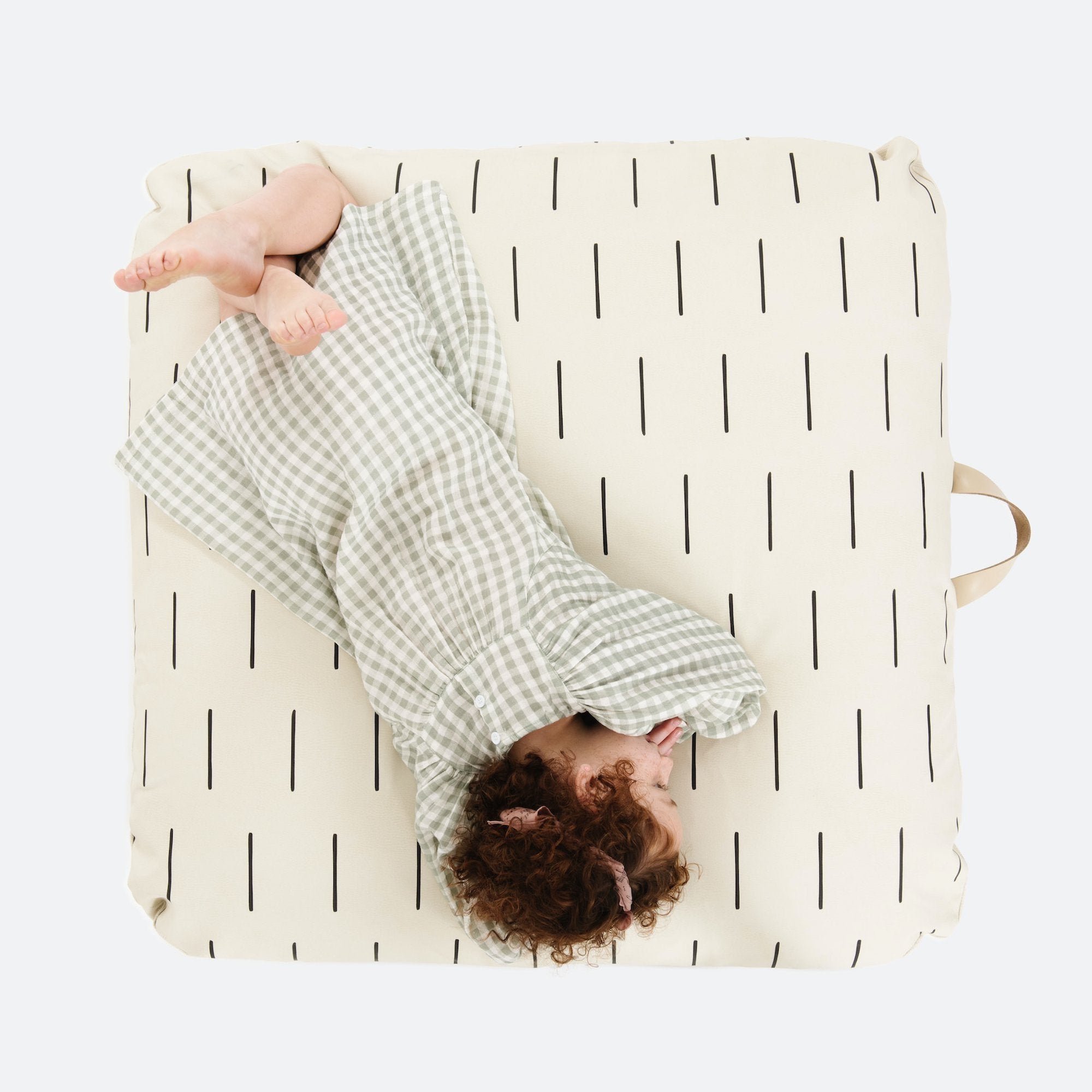 Blanc Dash (on sale) / Square@Overhead of kid laying on the Blanc Dash Square Floor Cushion
