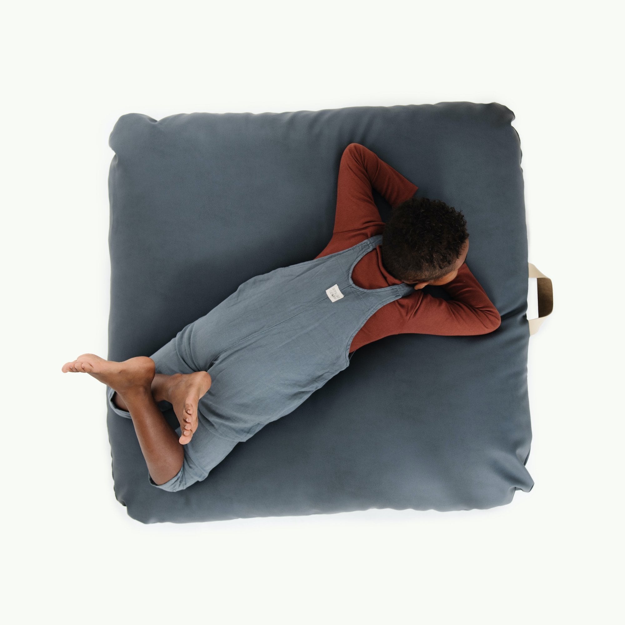 Nightfall (on sale) / Square@Overhead of kid sitting on the Nightfall Square Floor Cushion
