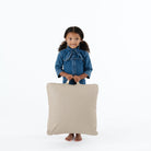 Ember (on sale) / Square@Kid holding the Ember Square Mini Floor Cushion