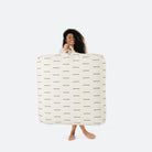 Blanc Dash (on sale) / Square@Woman holding the Blanc Dash Square Floor Cushion