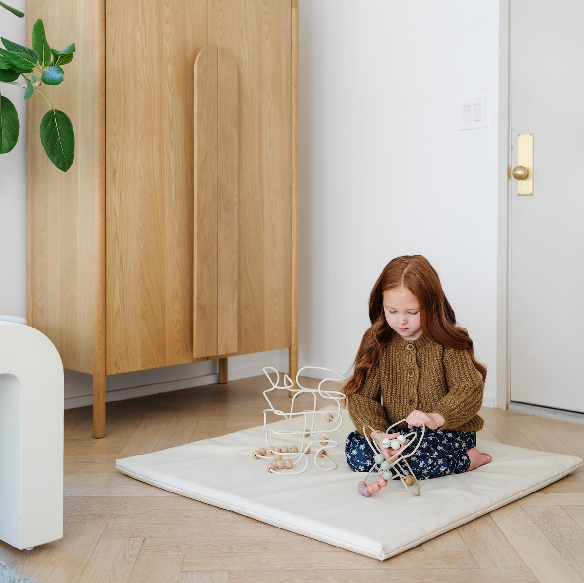 Ivory / Square@kid playing with toys on an ivory padded mini square mat
