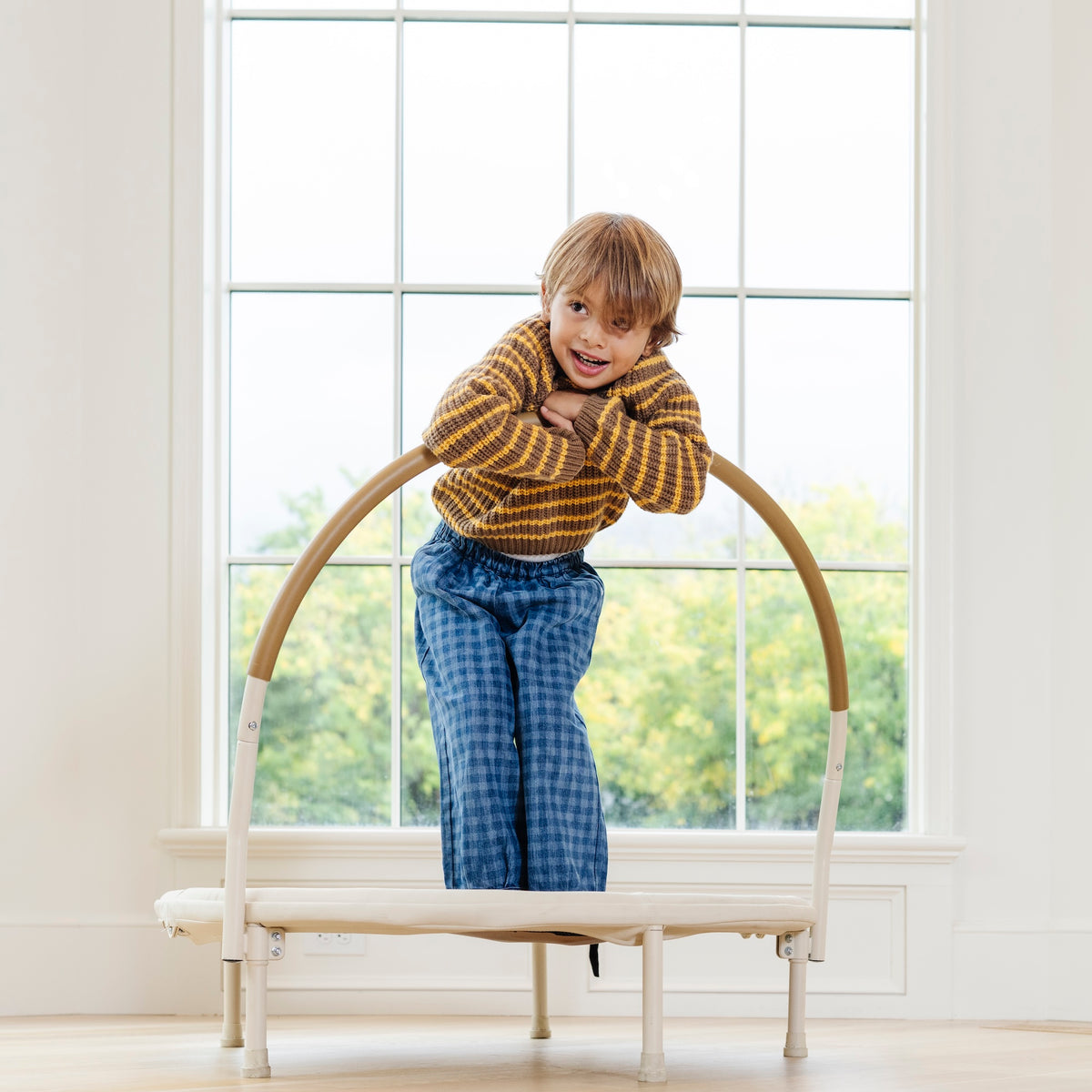 Ivory / Classic@Child using a low-profile indoor trampoline designed for balance and movement