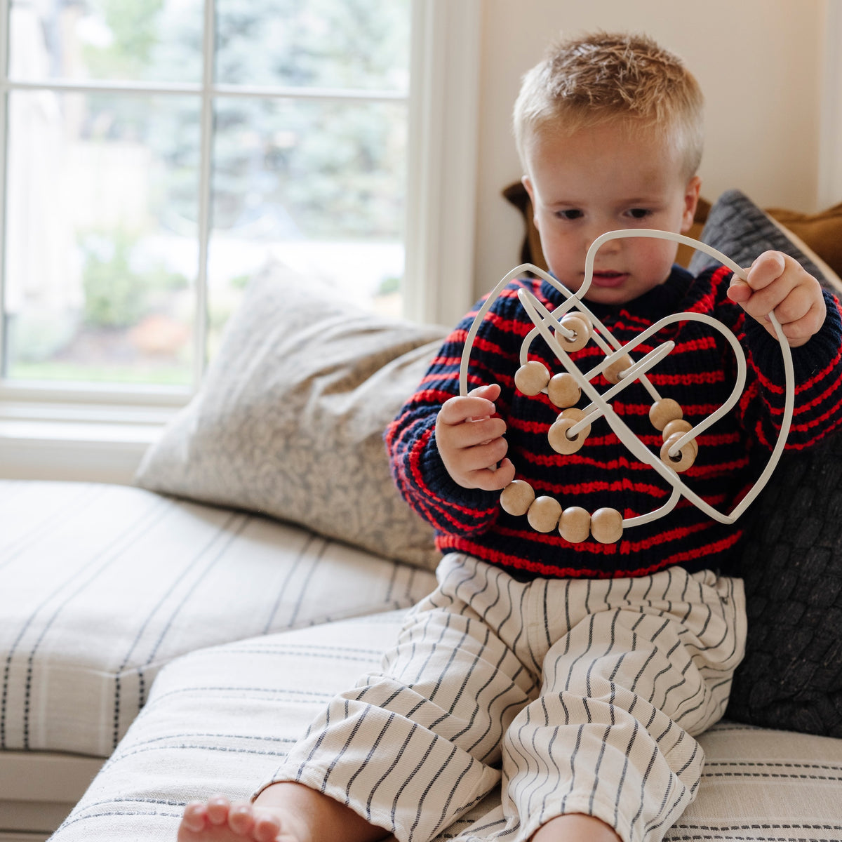 Ivory / Circle@Baby engaging with bead maze to build hand-eye coordination