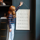 Alphabet@poster being hung by a little girl