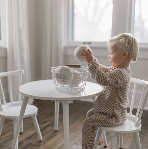 Ivory@Kid playing with the Ivory Play Ball Set on a table 