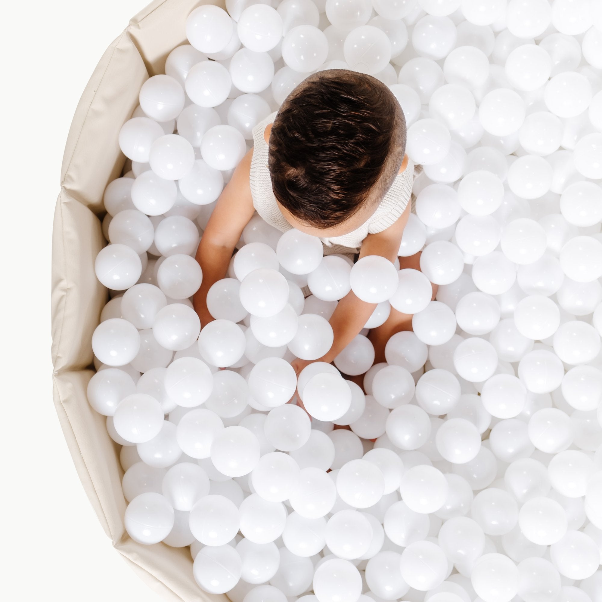 Ivory / Ball Pit@overhead of kid playing in the ivory ball pit