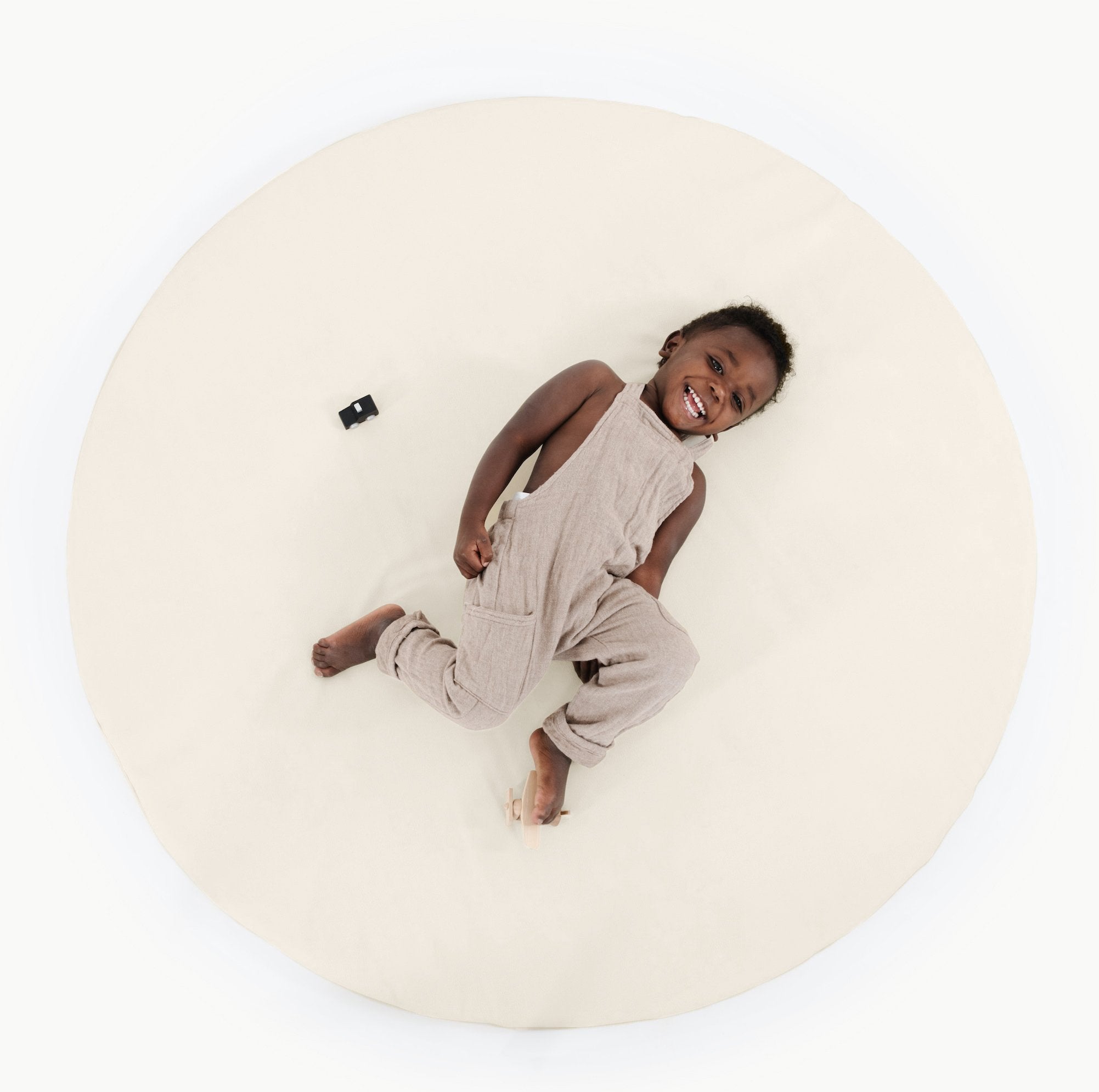 Ivory@overhead of child on ivory padded midi circle