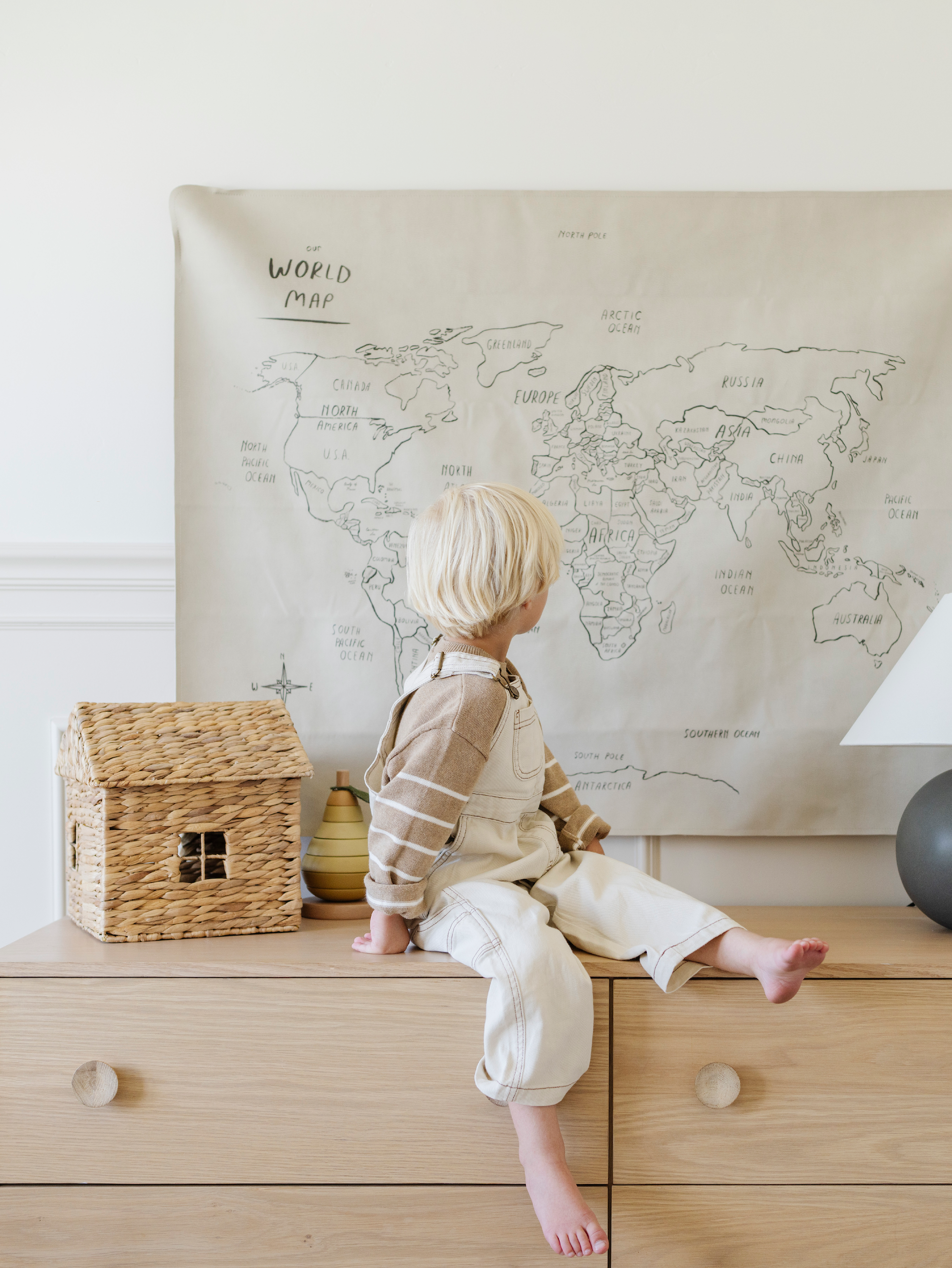 Kid sitting by the Gathre World Map Tapestry. 