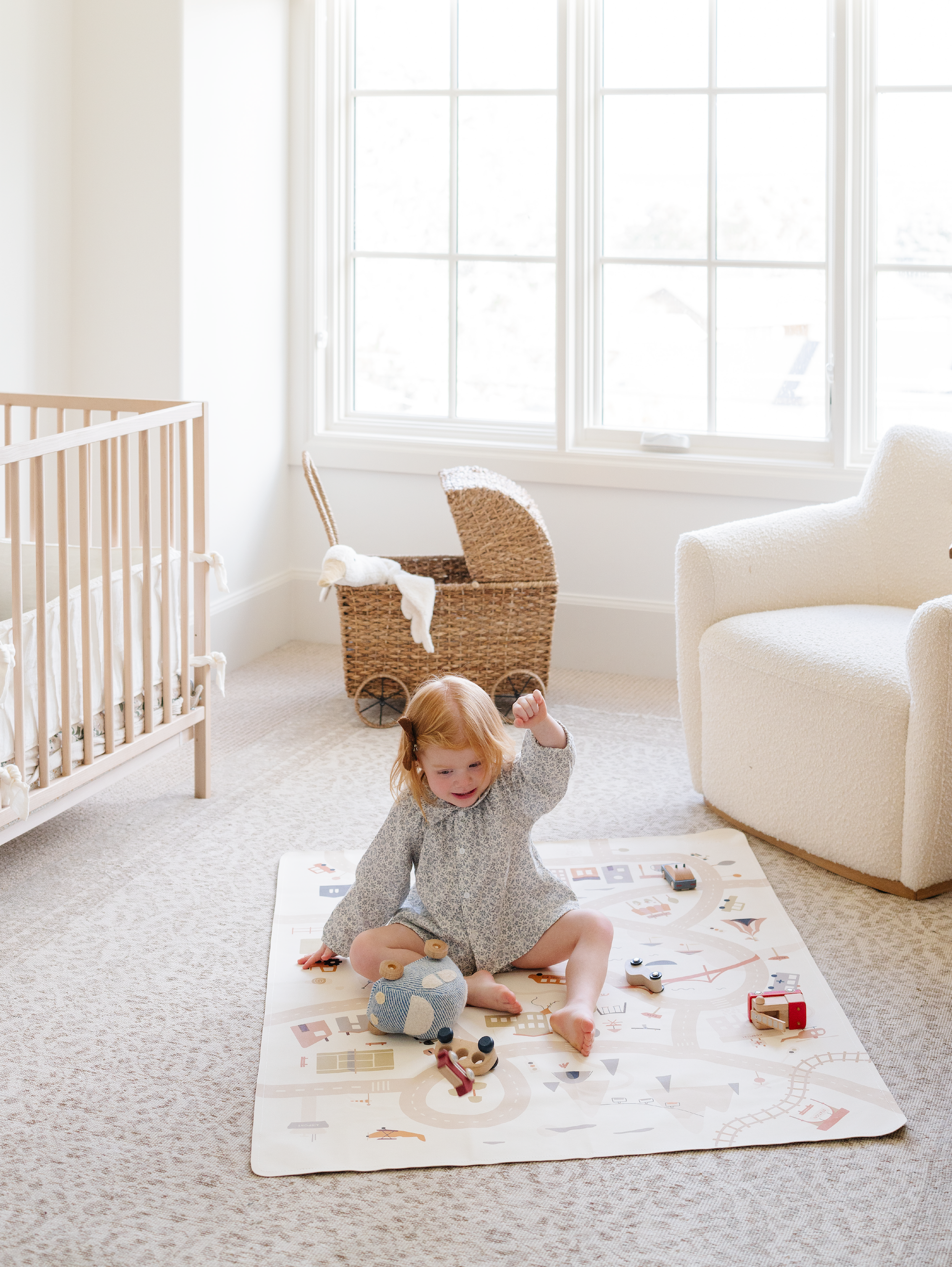 Kid playing on the Boulevard Mini+ Mat with some toys in a bedroom