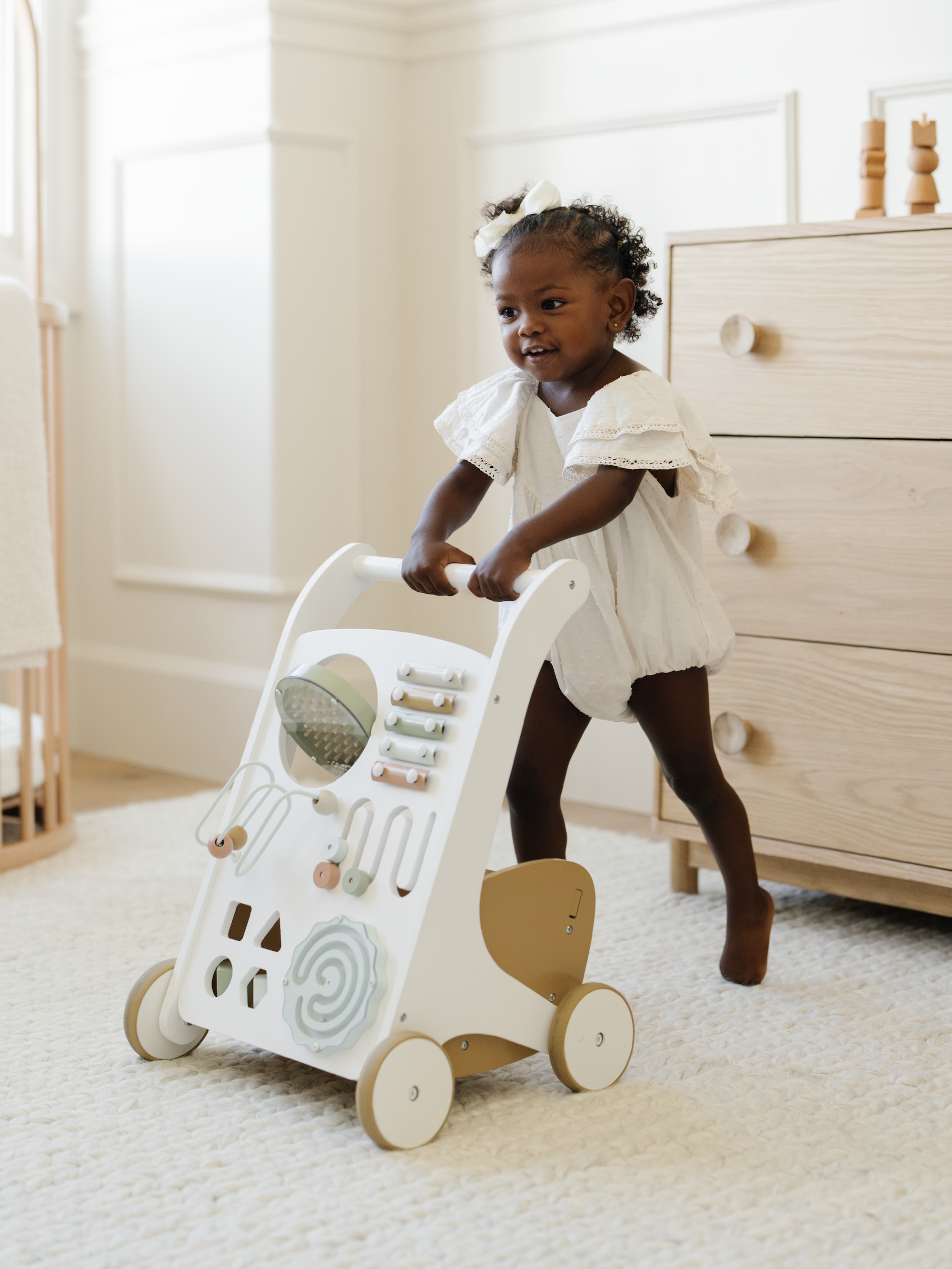 Kid playing with the Biscotti Activity Walker in a home.