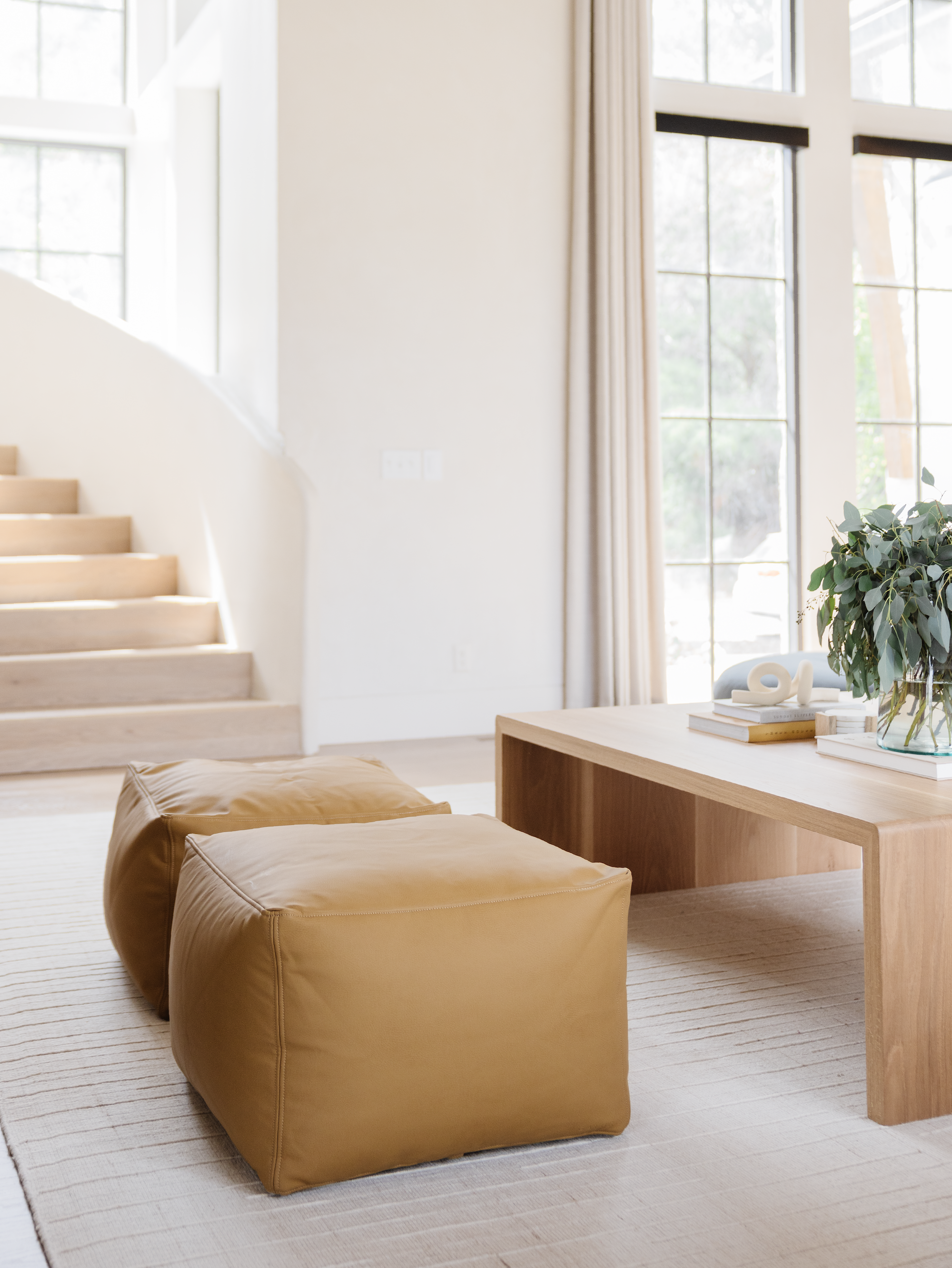 Two Poufs in front of a coffee table in a living room.