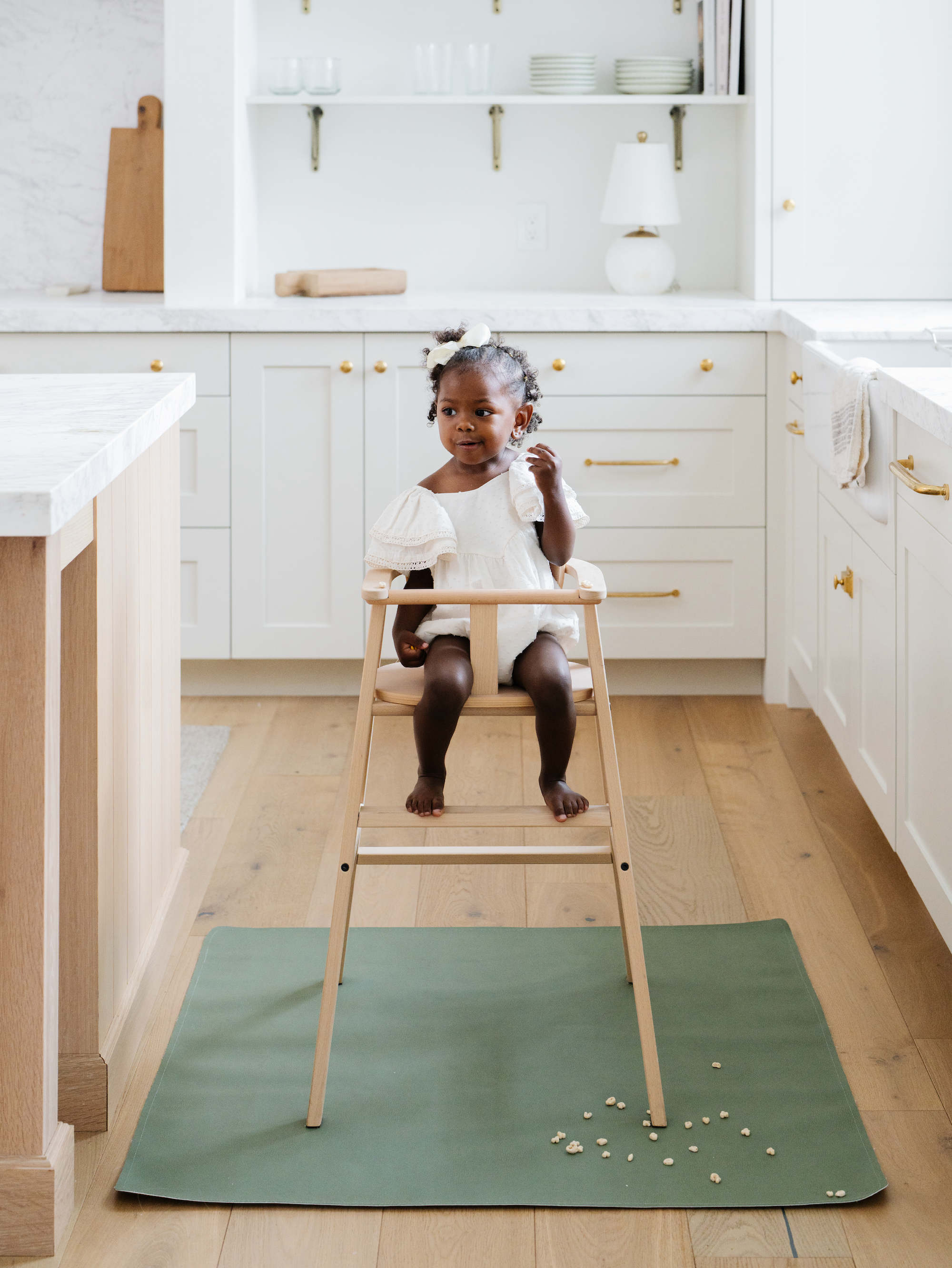 Baby in a highchair that's on a Gathre Mini Mat