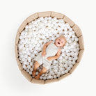 Millet@Overhead of kid laying in the Millet Ball Pit