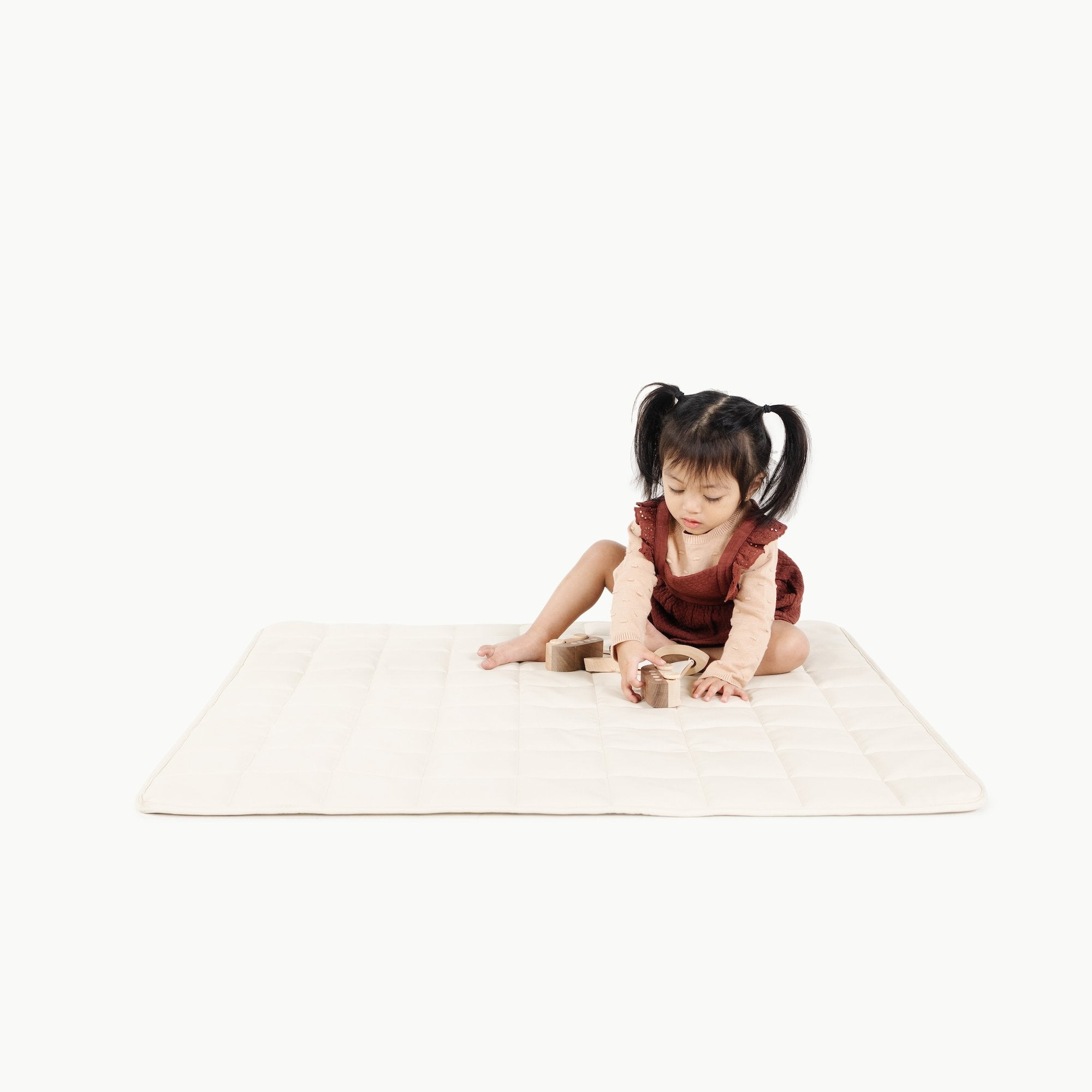 Ivory / Square@Kid sitting on the Ivory Mini Square Quilted Mat 