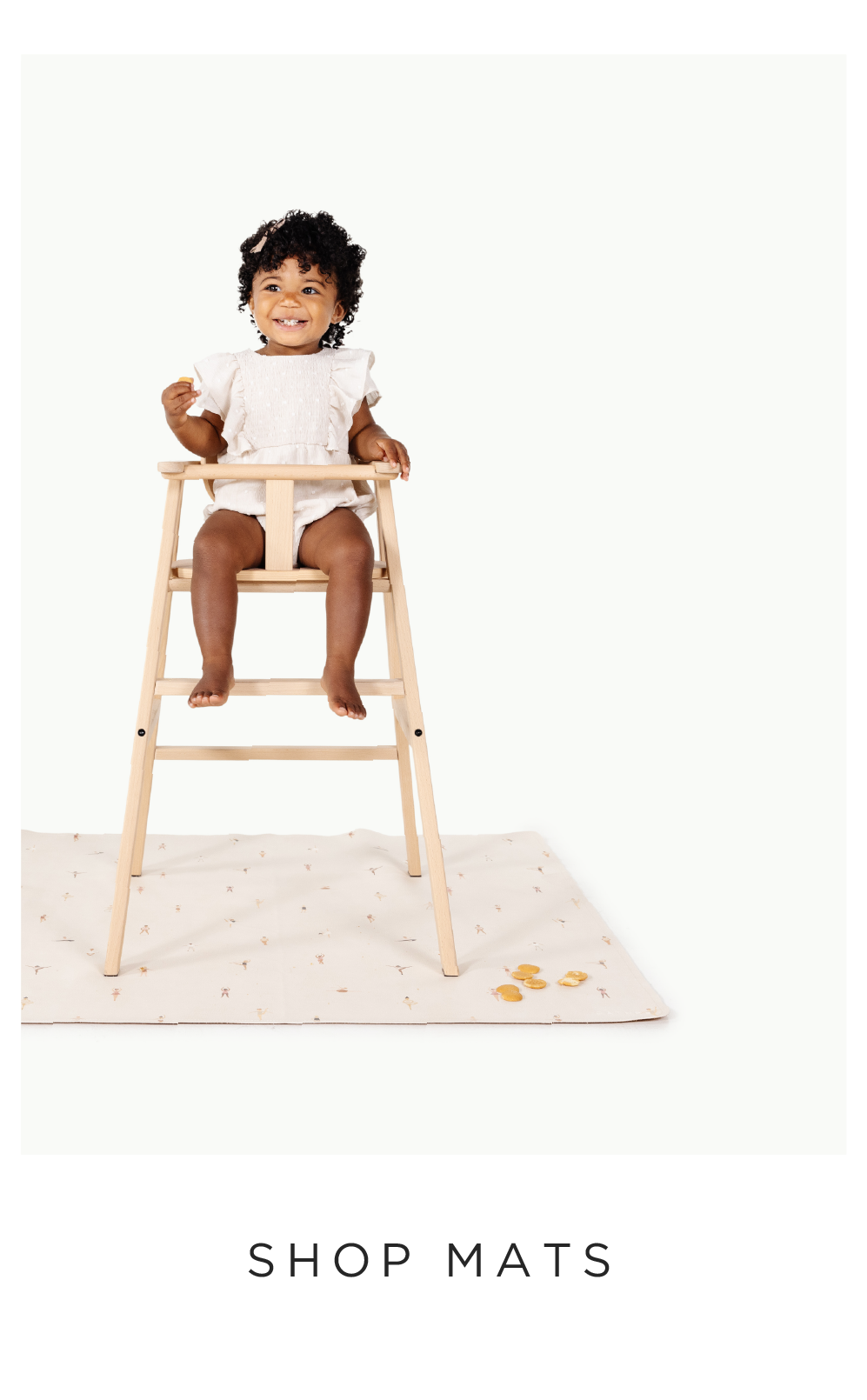 baby in a highchair on the mini mat