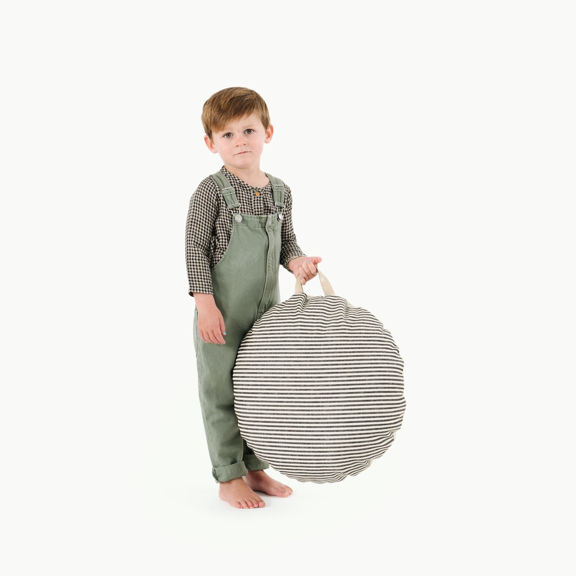 Stone Stripe / Circle@Kid holding the Stone Stripe Mini Circle Floor Cushion