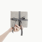 Stone Stripe (on sale)@someone holding a gift wrapped in stone stripe gift wrap