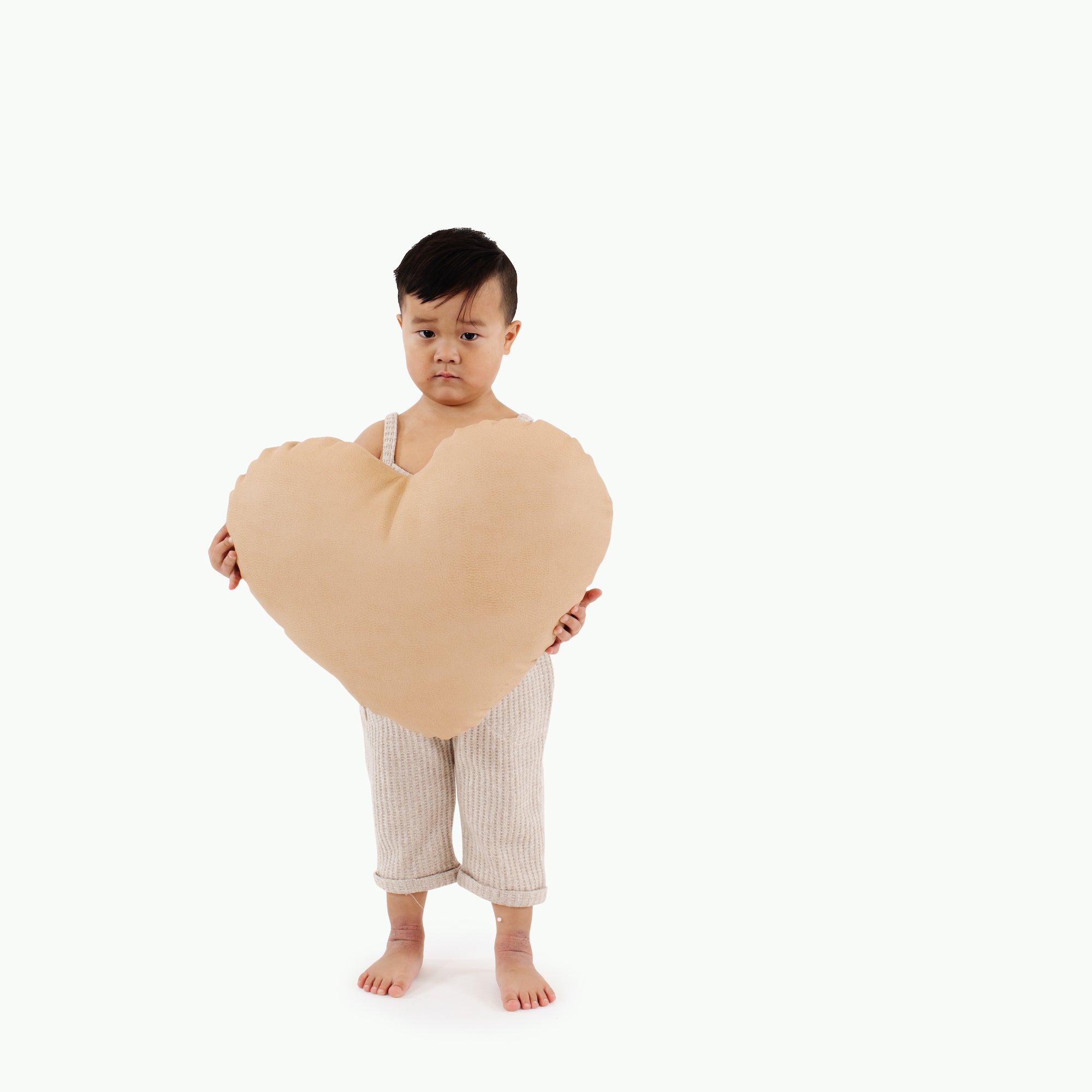 Untanned (on sale)@Kid holding the Untanned Heart Pillow